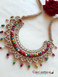 a crocheted necklace with beads and a rose