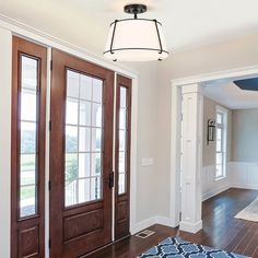 an empty room with two doors and a rug on the floor in front of it