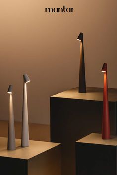 three different types of lamps sitting on top of pedestals in front of a wall