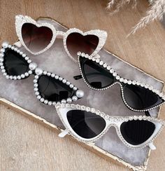 three pairs of heart shaped sunglasses with pearls