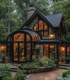 a very nice house in the woods with lots of windows and stone steps leading up to it