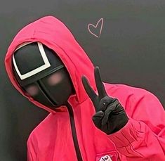 a person wearing a pink hoodie and giving the peace sign