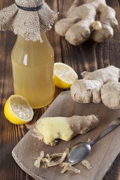 a wooden cutting board topped with sliced lemons and ginger