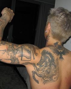 a man with tattoos on his back and arm