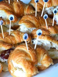 many croissants with googly eyes on them are arranged in a plate