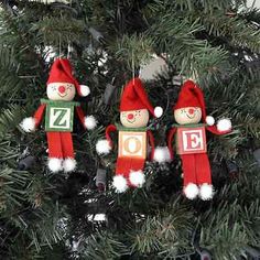 three ornaments hanging from a christmas tree in the shape of santa's helpers