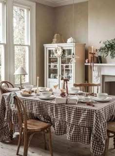 a dining room table is set with dishes and place settings