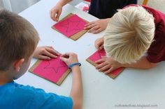 two children are making crafts on the table