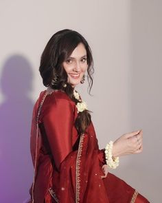 a woman in a red dress is posing for the camera with her hand on her hip