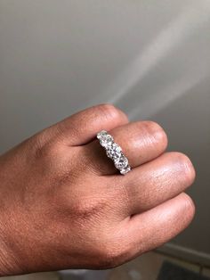 a person's hand with a diamond ring on it