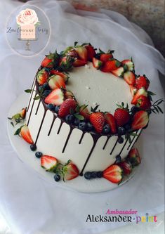 a white cake with strawberries and blueberries on top