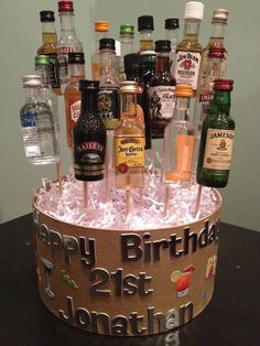 a birthday cake made to look like an ice bucket filled with liquor bottles