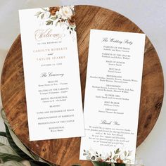 two wedding programs sitting on top of a wooden plate