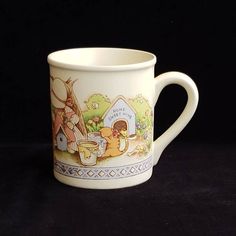 a white coffee cup with an image of alice and the neverland tea party on it