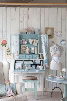 a room filled with furniture and decor on top of a wooden floor next to a white wall