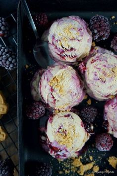 blackberry cheesecake muffins on a tray with fresh blackberries and raspberries