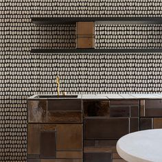 a kitchen with a sink, counter top and tiled backsplash in the background