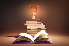 an open book sitting on top of a pile of books next to a light bulb