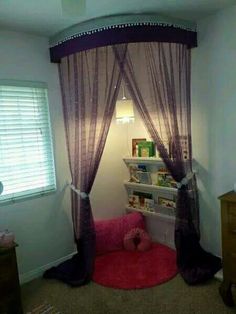 a room with a bed, book shelf and pink rug on the floor in front of it