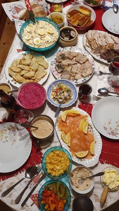 a table full of food and silverware on top of a cloth covered tablecloth