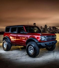 a red truck parked in front of a city skyline