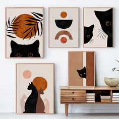 three black cats and one orange cat are hanging on the wall next to a dresser