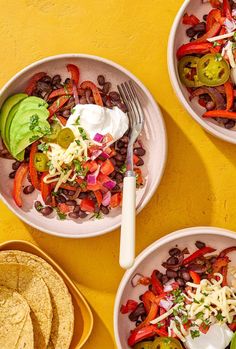 three bowls filled with different types of food on top of a yellow tablecloth next to tortilla chips