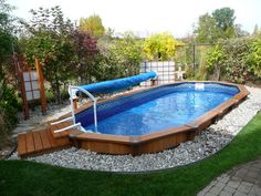 an above ground swimming pool surrounded by landscaping