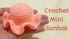 a crochet mini sunhat is in someone's hand