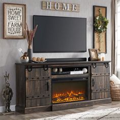 an entertainment center with a fireplace in the middle and pictures on the wall above it