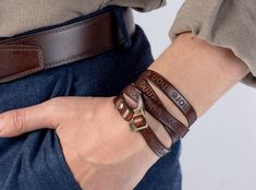 a person wearing two leather bracelets on their wrist