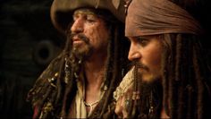 two men with dreadlocks on their heads and one wearing a bandana, the other in a pirate costume