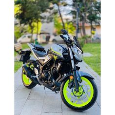 a black and yellow motorcycle parked on the sidewalk