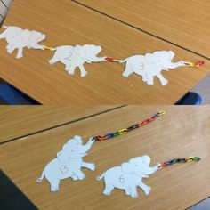 cut out elephants are being displayed on the table with beaded string attached to them