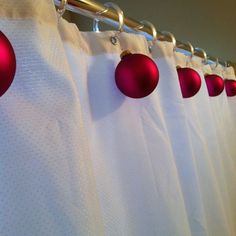 red ornaments are hanging on the shower curtain