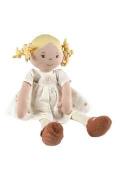 a small doll with blonde hair sitting on the ground