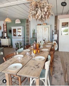 a dining room table is set with plates and glasses on it, next to an old door