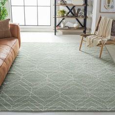 a living room with a couch, chair and rug on the floor in front of a window