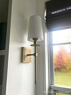 a lamp on the wall next to a window