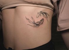 a woman with a tattoo on her stomach has a koi fish in the shape of a heart