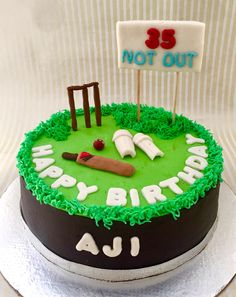 a birthday cake decorated with green frosting and white icing, featuring a cricket theme