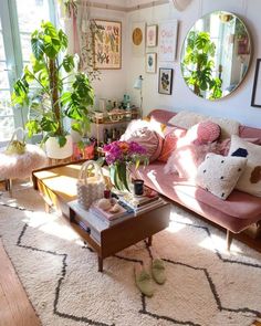 a living room filled with lots of furniture and plants on top of a white rug