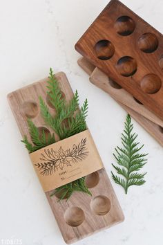 two wooden trays with plants on them next to some holes in the wood that are used as plant markers