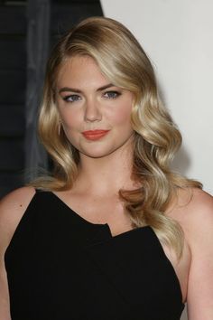 a woman with long blonde hair wearing a black dress