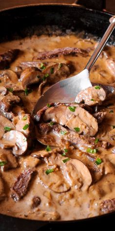 a skillet filled with meat and mushroom covered in gravy