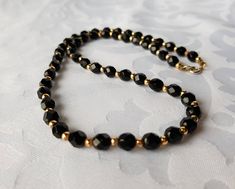 Vintage black glass faceted bead necklace. The round black beads measure about 5 mm round and have many facets for added sparkle, they are separated by small gold tone beads for added contrast. The total length of the necklace is 18 inches. The spring ring closure works perfectly, it has faded over time giving it a more silver tone. It is quite small and not noticeable when worn. It is in very good vintage condition. Wound complement any holiday outfit or little black dress. I'll ensure your ord Black Faceted Beaded Necklaces For Party, Black Faceted Beaded Necklaces, Black Faceted Round Beaded Necklaces, Formal Black Beaded Necklace With Faceted Beads, Formal Black Faceted Beaded Necklaces, Formal Black Faceted Beaded Necklace, Black And Gold Necklace, Beaded Necklace Black, Faceted Bead Necklace