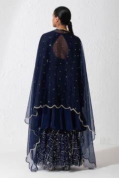 Midnight blue short anarkali with a round neckline, full length sleeves and cutout at the back. Comes with sequin embroidered gharara, scallop border dupatta and an embroidered belt.
Components: 4
Pattern: Embroidered
Type Of Work: Zardozi and Sequin
Neckline: Round
Sleeve Type: Long
Fabric: Crepe, Organza and Net
Color: Blue
Other Details: 
Dupatta with embroidered scallop border
Zardozi embroidered belt with scallop border
Cutout at the back
Note: The potli bag carried and choker worn by the m Blue Sharara With Dori Work For Party, Blue Georgette Sharara With Gota Work, Royal Blue Sharara With Pallu For Diwali, Blue Sharara With Sheer Dupatta For Eid, Blue Sharara For Navratri Festival, Blue Sharara For Navratri Festive Occasion, Festive Blue Sharara With Dupatta, Unstitched Blue Sharara With Gota Work, Blue Chanderi Sharara With Dupatta