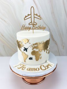 a white and gold birthday cake with an airplane on top