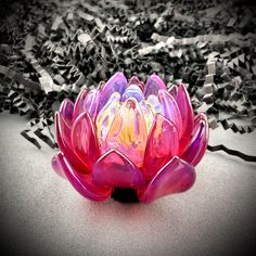 a pink glass flower sitting on top of a table