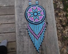 a beaded dream catcher on a piece of wood